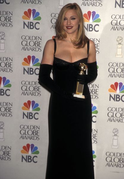 Madonna wearing a black dress with matching gloves