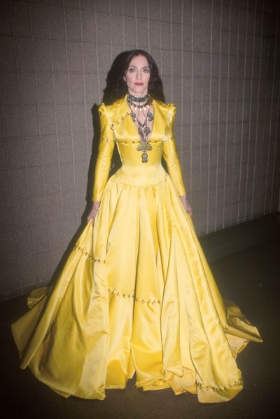 Madonna in a fitted bodice with full skirted yellow gown