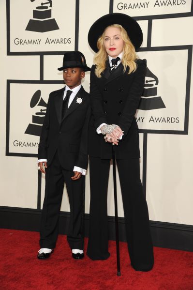 Madonna wearing a black suit with hat and cane