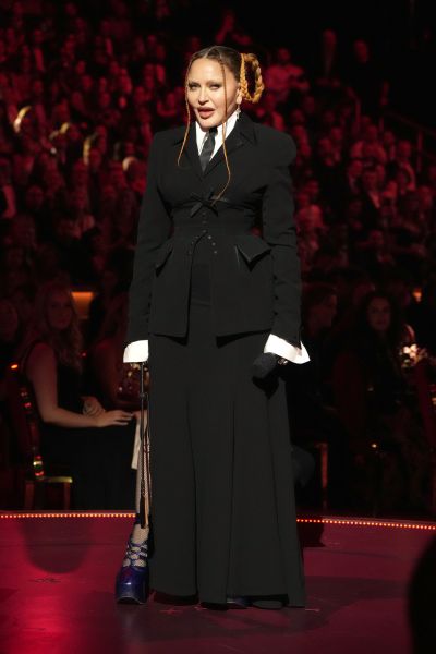 Madonna wearing a full black suit with skirt